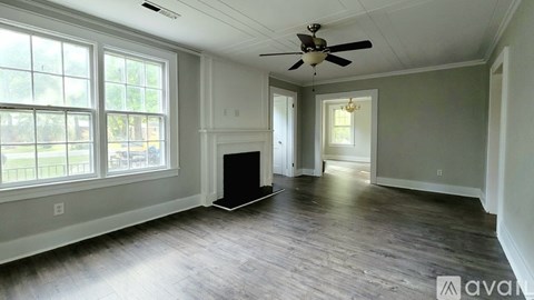 A spacious room with a ceiling fan and a black speaker on the floor.