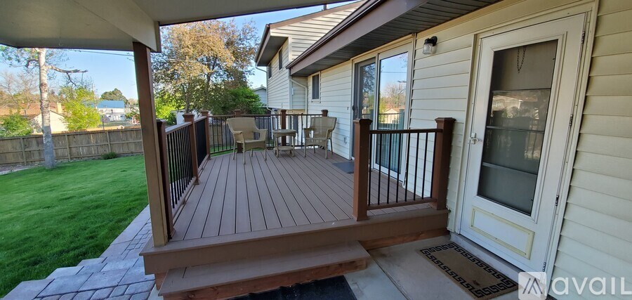 A wooden deck with a bench and a railing.