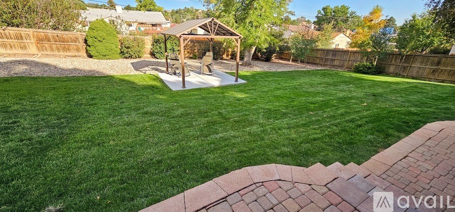 A backyard with a gazebo and a fence.