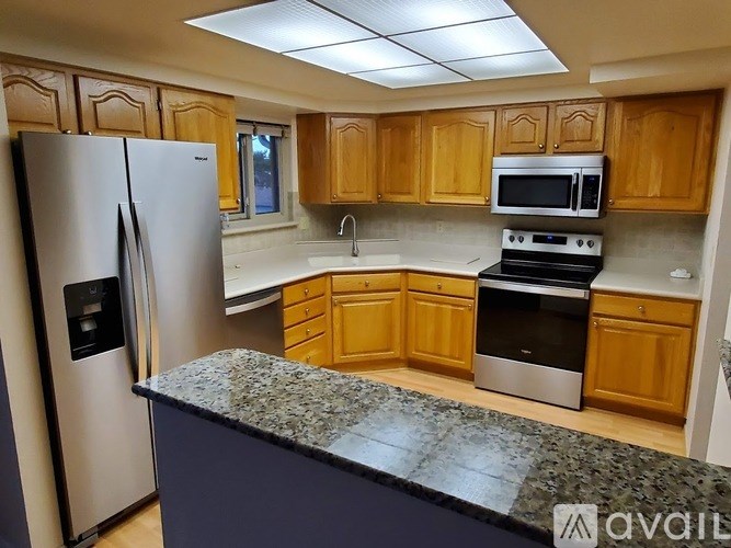 A kitchen with wooden cabinets and granite countertops.