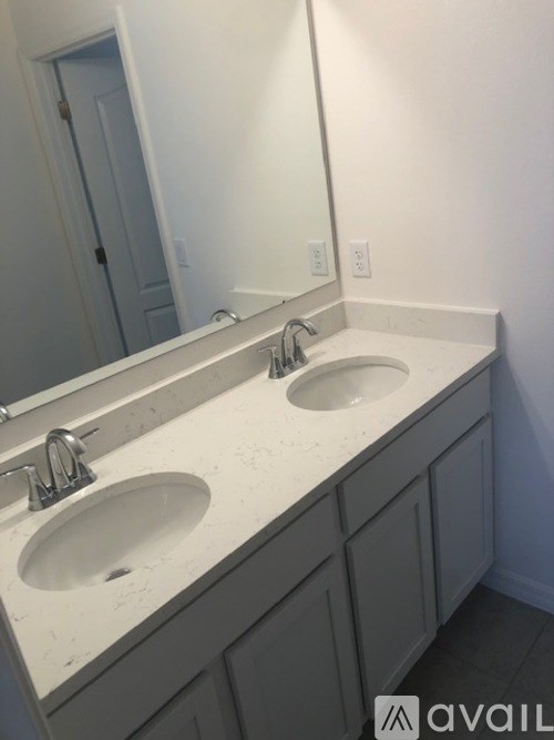 A bathroom with two sinks and a mirror.