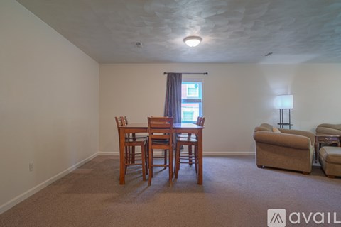 A living room with a dining table and chairs.
