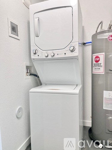 A white oven with a door open and a stop sign on the wall.