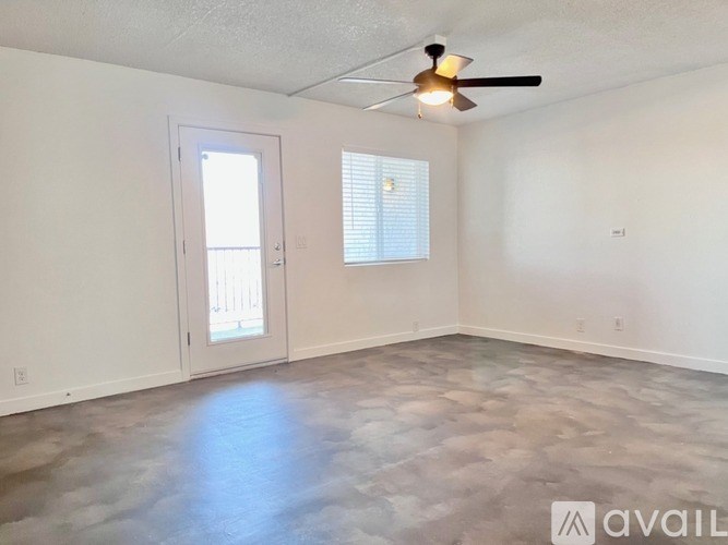 A room with a ceiling fan and a door leading to a balcony.