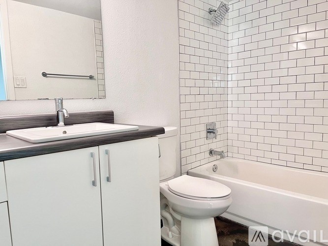 A white toilet sits next to a bathtub in a bathroom.