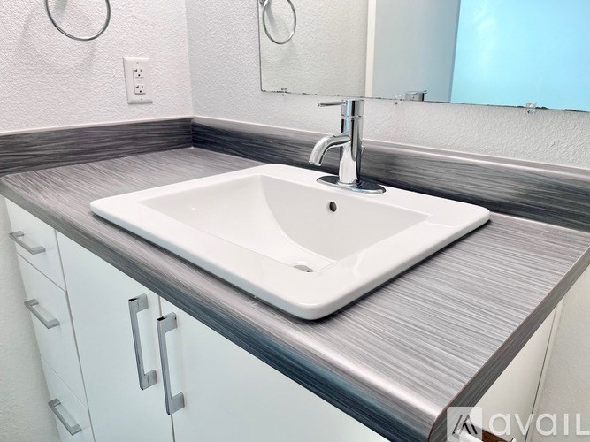A white sink is on a countertop in a bathroom.