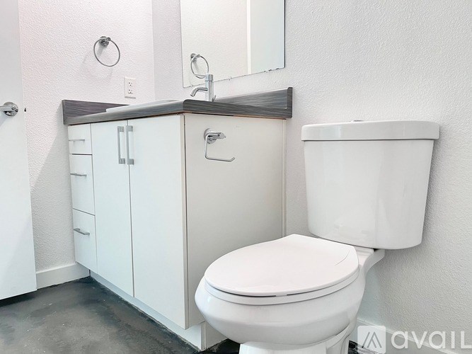 A white toilet sits next to a white cabinet in a bathroom.