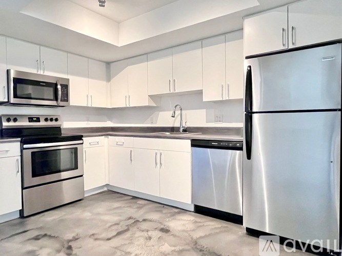 A modern kitchen with stainless steel appliances and white cabinets.
