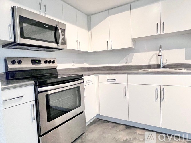 A kitchen with white cabinets and stainless steel appliances.