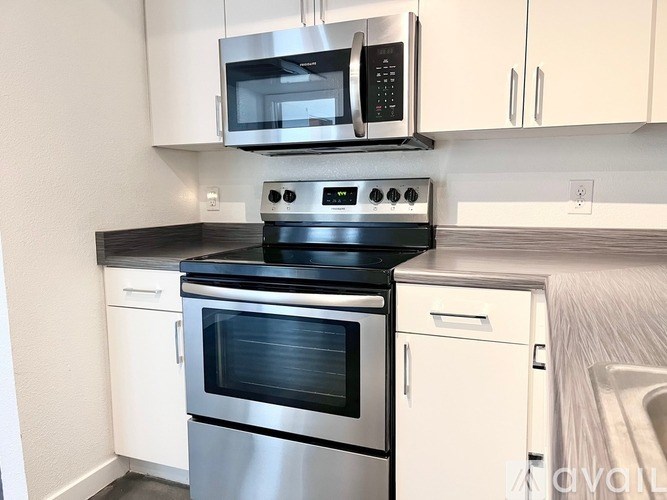 A modern kitchen with a stainless steel oven and microwave.