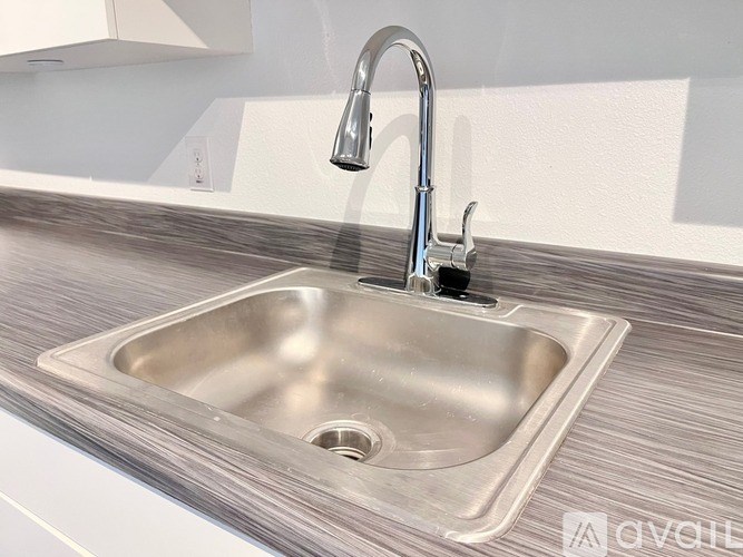 A modern kitchen sink with a chrome faucet.