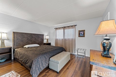 A bedroom with a large bed and a bench in front of it.