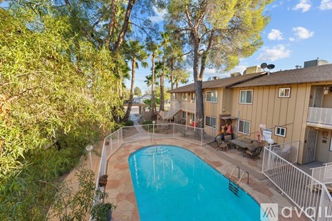 A swimming pool surrounded by a fence and trees.
