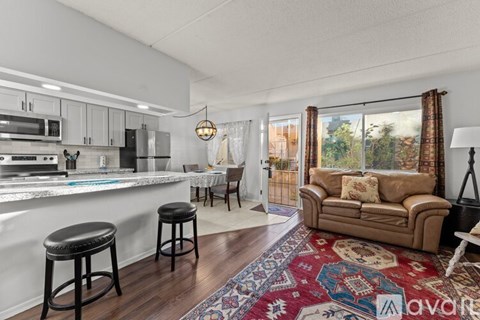 A kitchen with white cabinets and a black fridge is shown.