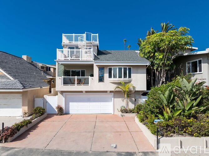 A two-story house with a balcony and a garage.