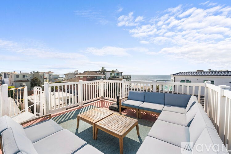 A balcony with white furniture and a wooden table.