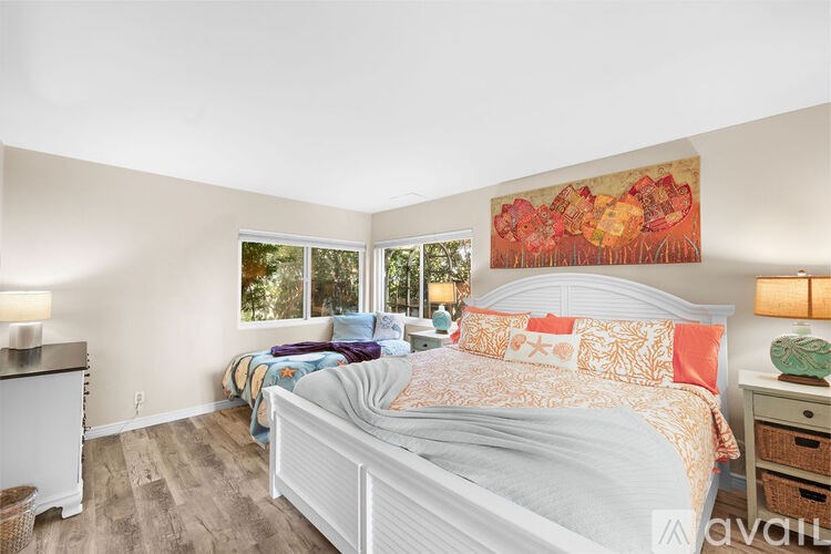 A bedroom with a large bed and a painting on the wall.