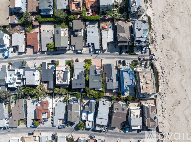 A bird's eye view of a residential area with houses and a beach.