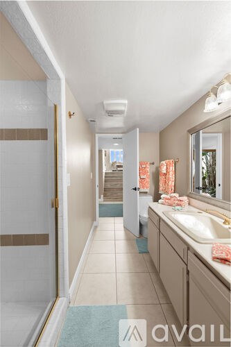 A bathroom with a sink, mirror, and a blue rug.