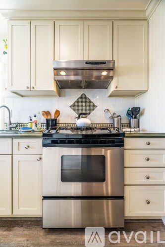 A kitchen with a stove top oven and a range hood above it.