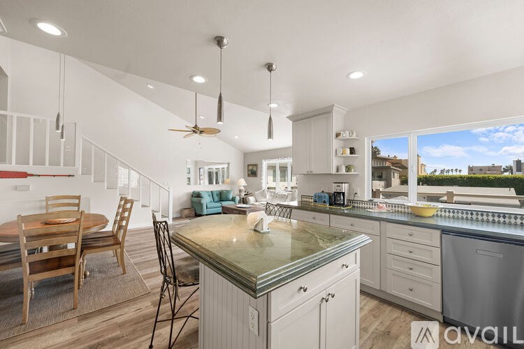 A kitchen with a table and chairs and a fan.