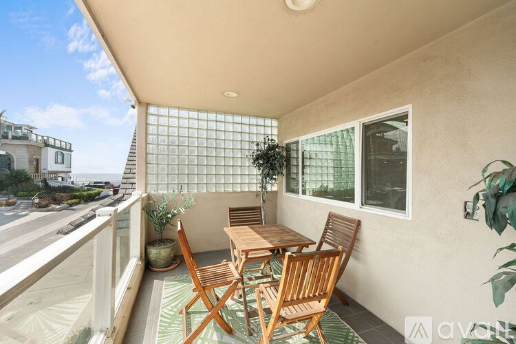 A balcony with a table and chairs overlooking a city street.