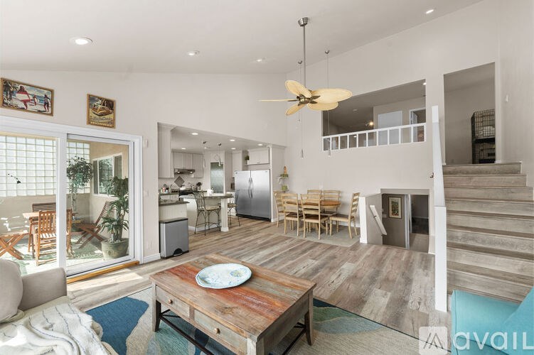 A modern open plan living and dining area with a kitchen in the background.