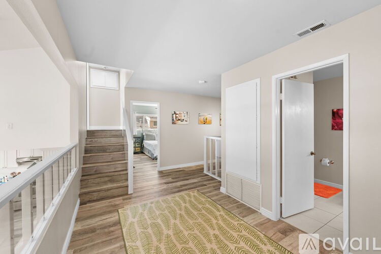 A hallway with a carpeted floor and white walls.