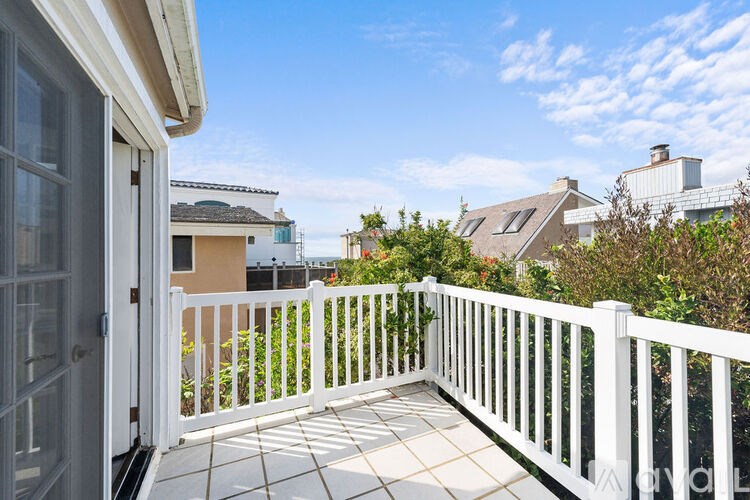 A white balcony with a white railing and a white door.