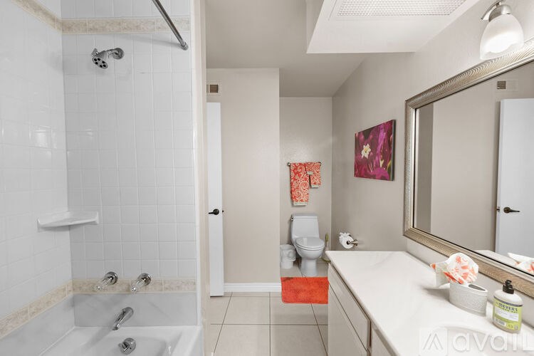 A bathroom with a white tub and a toilet.