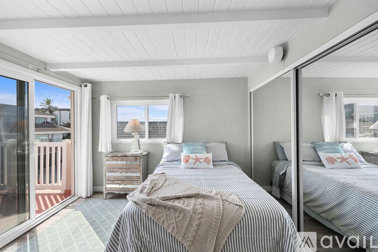 A bedroom with two beds and a balcony.