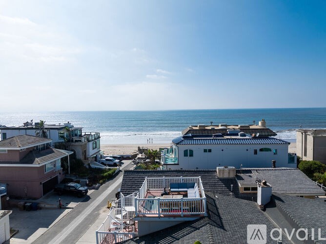 A beachfront property with a balcony overlooking the ocean.