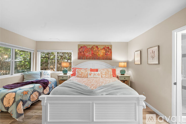 A bedroom with a large bed and a painting on the wall.