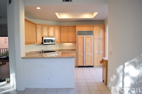 A kitchen with wooden cabinets and a white island.