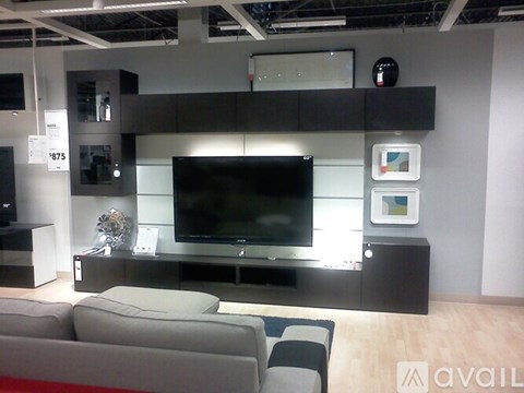 A modern living room with a grey sofa and a black television.