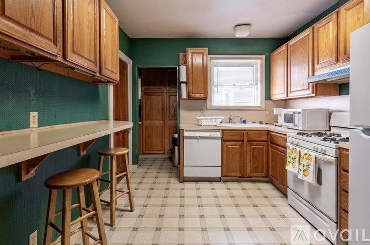 A kitchen with green walls and wooden cabinets.