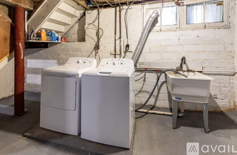 A white washing machine and dryer in a basement.