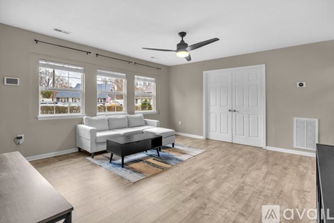 A living room with a white couch and a ceiling fan.