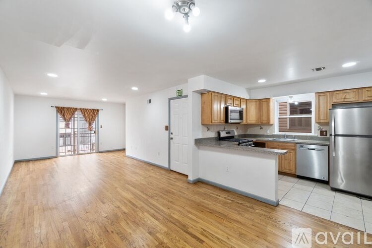 A kitchen with wooden floors and stainless steel appliances.