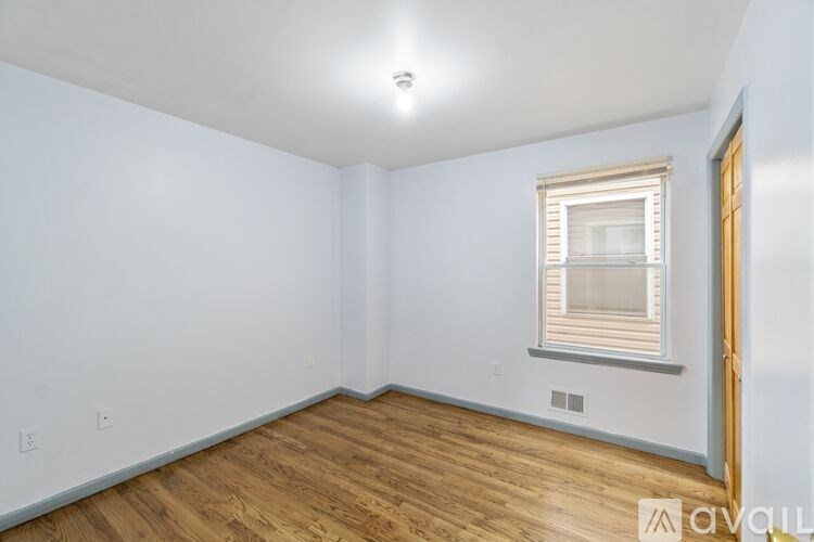 A room with a window and wooden flooring.