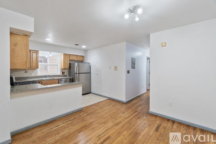 A kitchen with wooden floors and white walls.