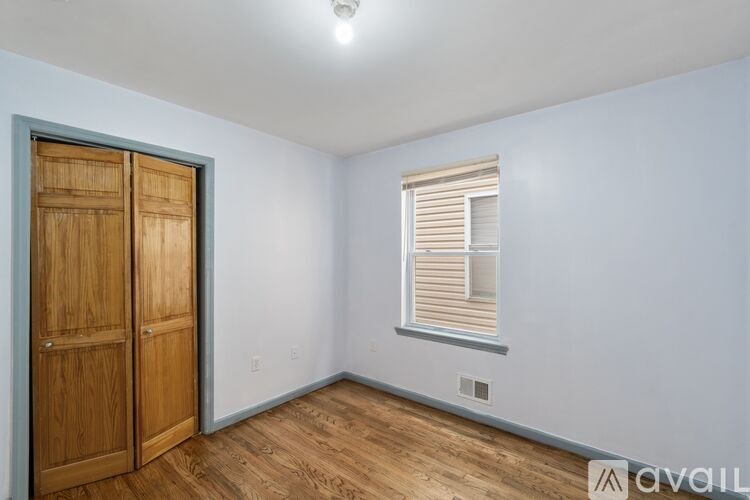 A room with a wooden door and a window with blinds.