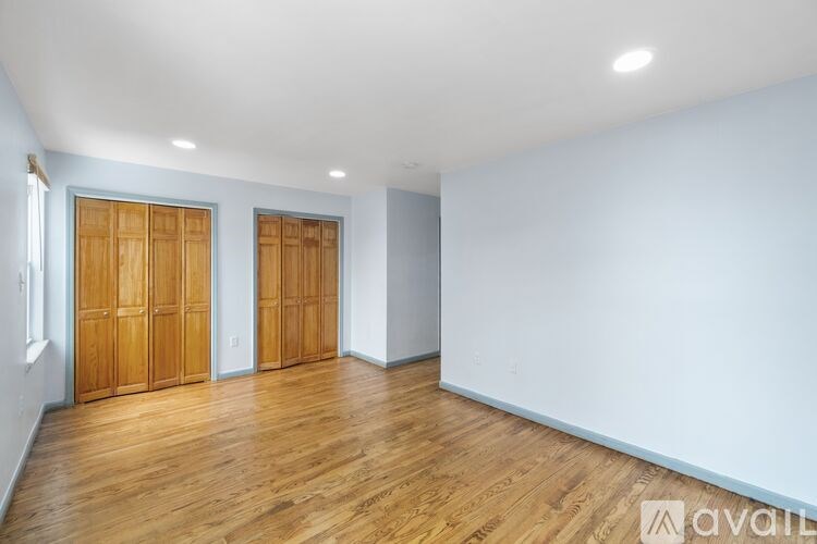 A room with wooden floors and two wooden doors.