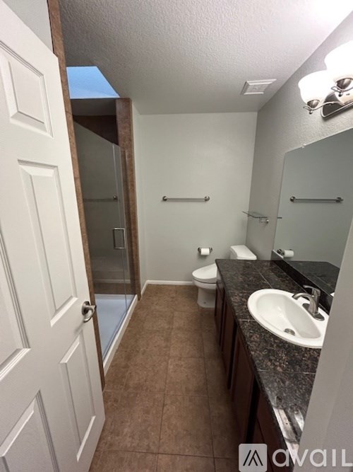 A bathroom with brown tile floors and a white door.