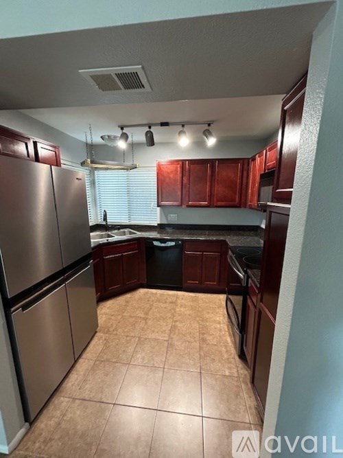 A kitchen with a refrigerator, oven, and cabinets.