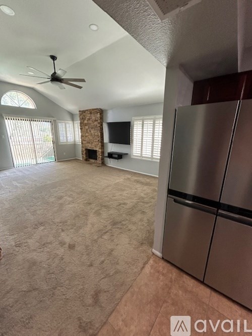 A modern kitchen with a stainless steel refrigerator and a fan on the ceiling.