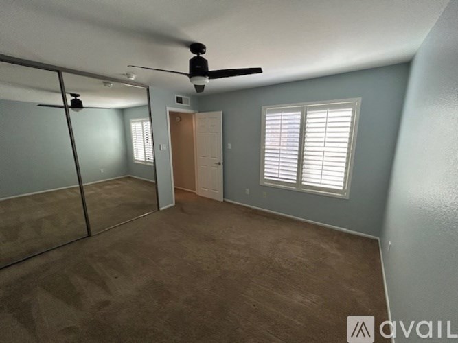A room with a ceiling fan and a door.