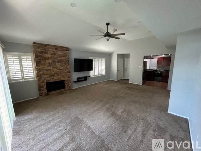 A living room with a fireplace and a flat screen TV mounted on the wall.