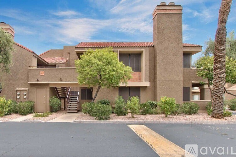 A house with a brown roof and a tree in front.