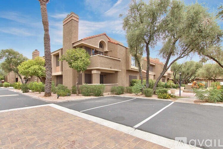 A house with a driveway and trees in front.
